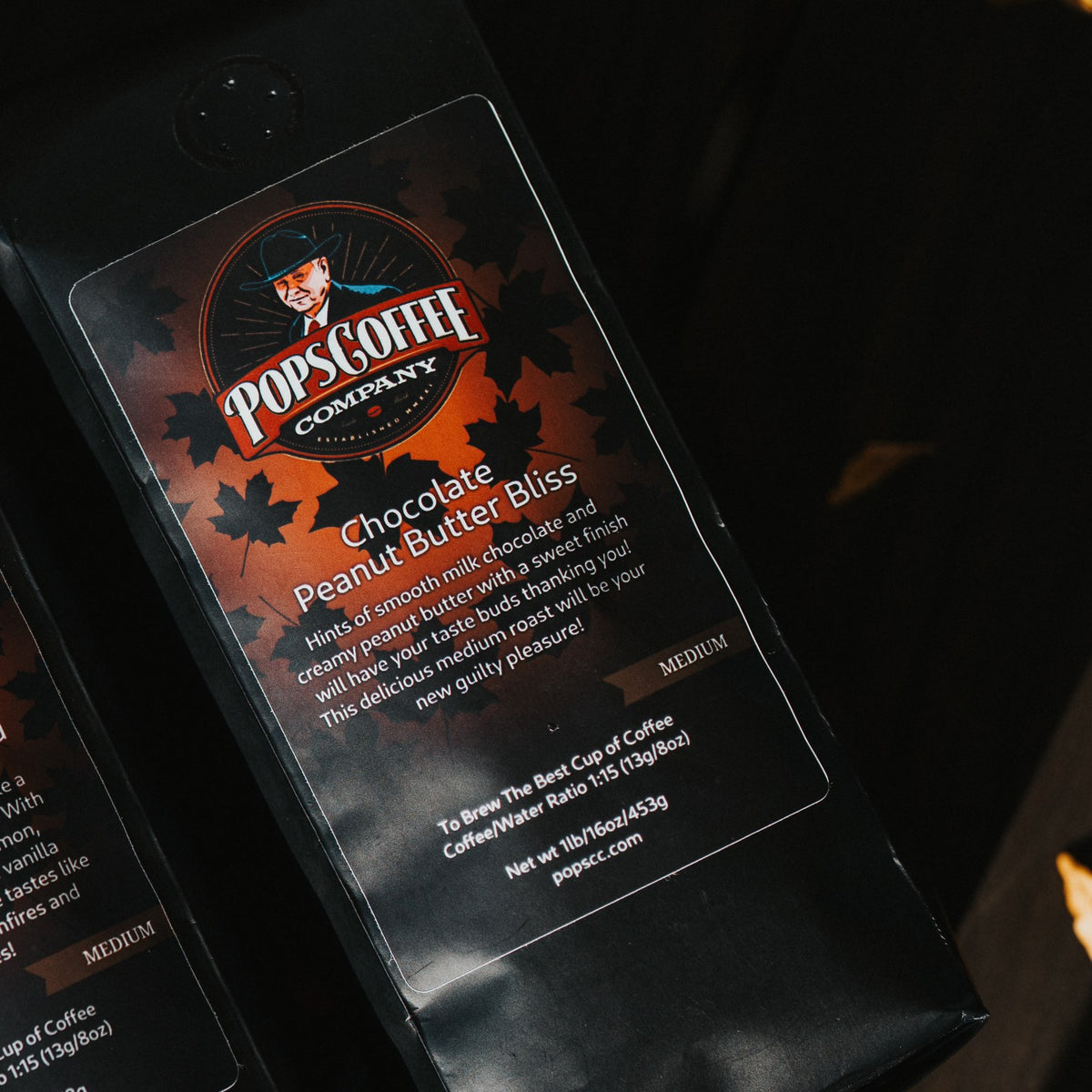 Pops Chocolate Peanut Butter Bliss bag on a wooden bench with fall leaves