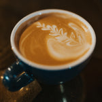 A latte with rosetta latte art made with Pops Coffee