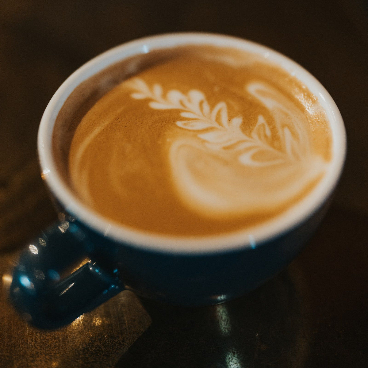 A latte with rosetta latte art made with Pops Coffee