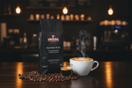 Pops Coffee Company Espresso Roast bag on dark wood at a specialty coffee bar with cappuccino and perfect microfoam latte art