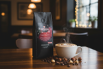 Pops Coffee Company Toasted Hazelnut bag on a dark wood cafe surface with steaming hazelnut latte and roasted hazelnuts