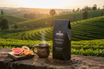 Pops Coffee Company Kenya Peaberry bag on stone in the Kenyan highlands with coffee terraces and apricots at sunrise