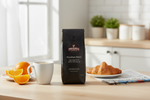 Pops Coffee Company Breakfast Blend bag on a bright breakfast table with steaming coffee, orange slices and croissant