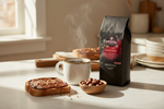 Pops Coffee Company Toasted Hazelnut bag on a marble counter with steaming coffee, hazelnuts and hazelnut spread on toast