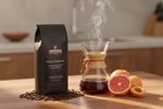 Pops Coffee Company Kenya Peaberry bag with pour-over coffee, grapefruit slices and apricots evoking bold wine and fruit notes