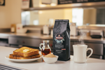 Pops Coffee Company French Toast bag on a diner counter with brioche French toast, maple syrup and diner coffee mug