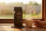Pops Coffee Company Breakfast Blend bag on a kitchen windowsill at sunrise with steaming mug of light roast coffee