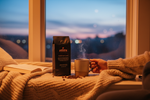 Pops Coffee Company Sweet Dreams Decaf bag on a cozy window seat at dusk with steaming mug and soft blanket